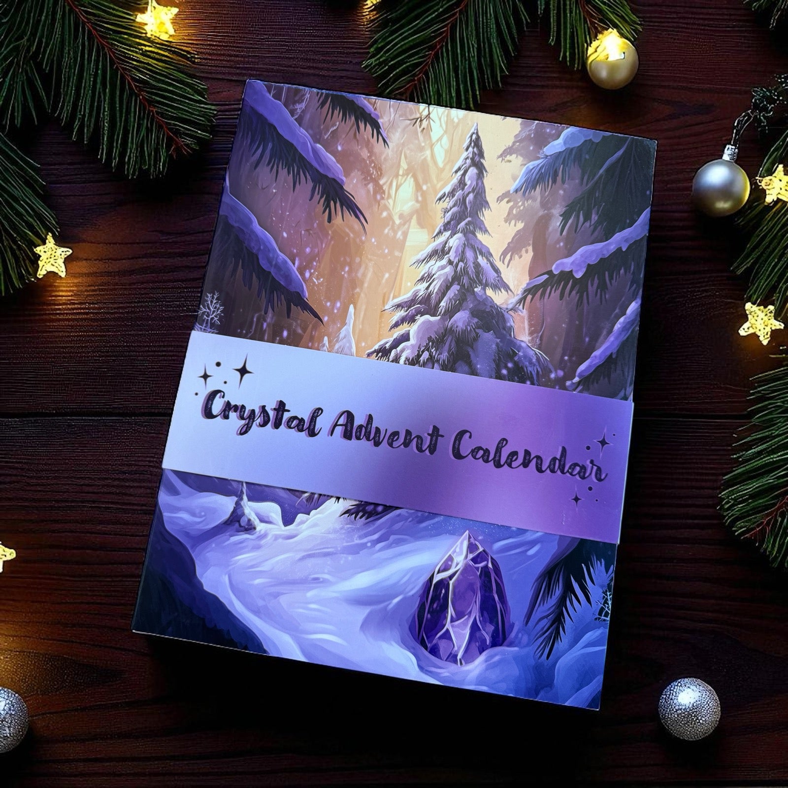 Adventskalender von mysoulspirit auf braunem Holz mit Weihnachtsdeko. Der Kalender zeigt eine Illustration einer verschneiten Tannenlandschaft mit einem Amethyst im Schnee im Vordergrund. Der gesamte Kalender ist in Lilatönen gehalten und hat eine Banderole.