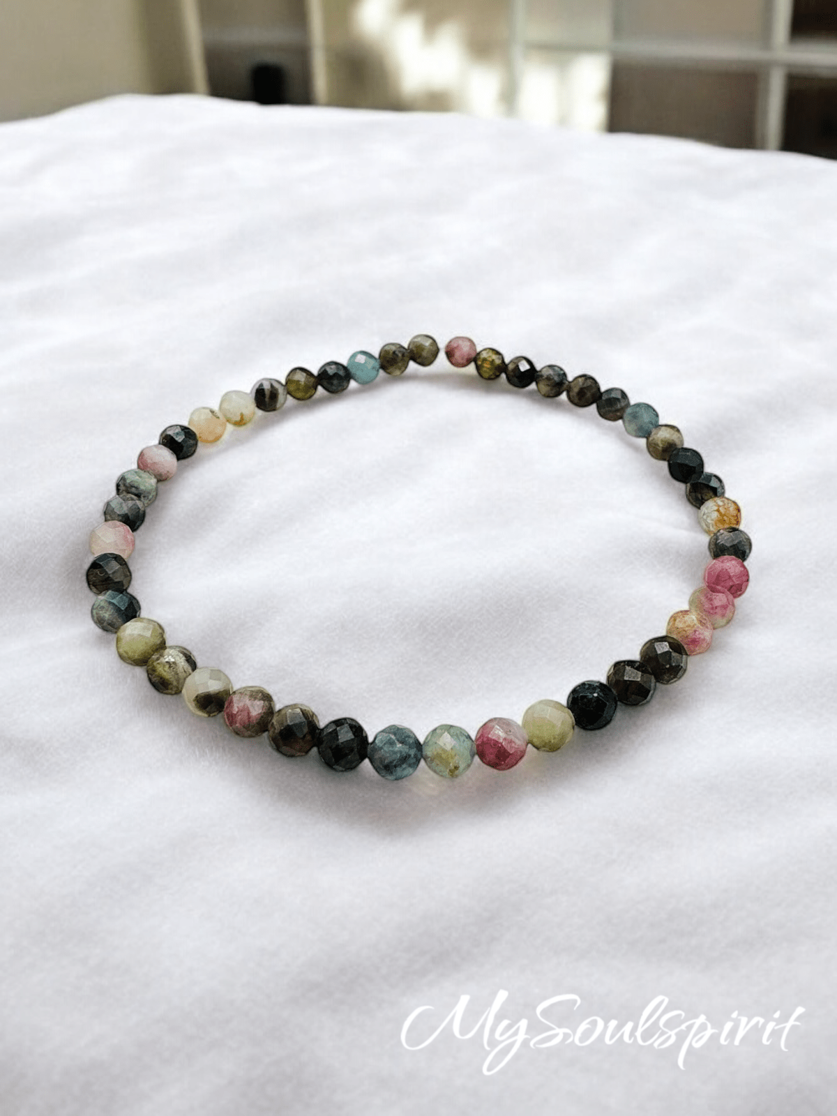 Turmalin multicolor Armband 4 mm facettiert auf weißem Stoff als Detailaufnahme