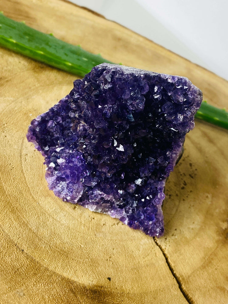 Amethyst Druse auf Marmorplatte vor Holzhintergrund