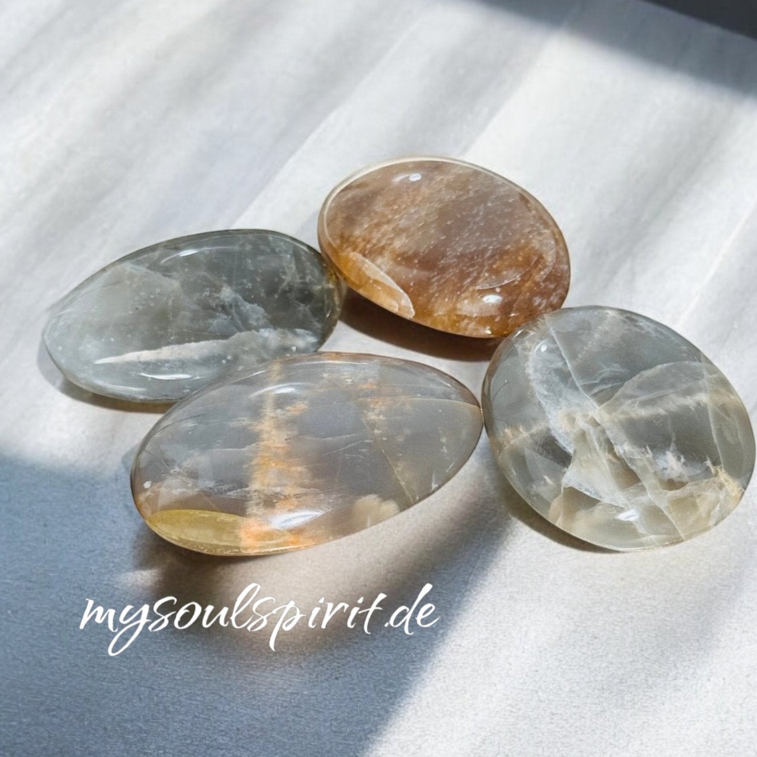 Vier Handschmeichler auf grauem Untergrund