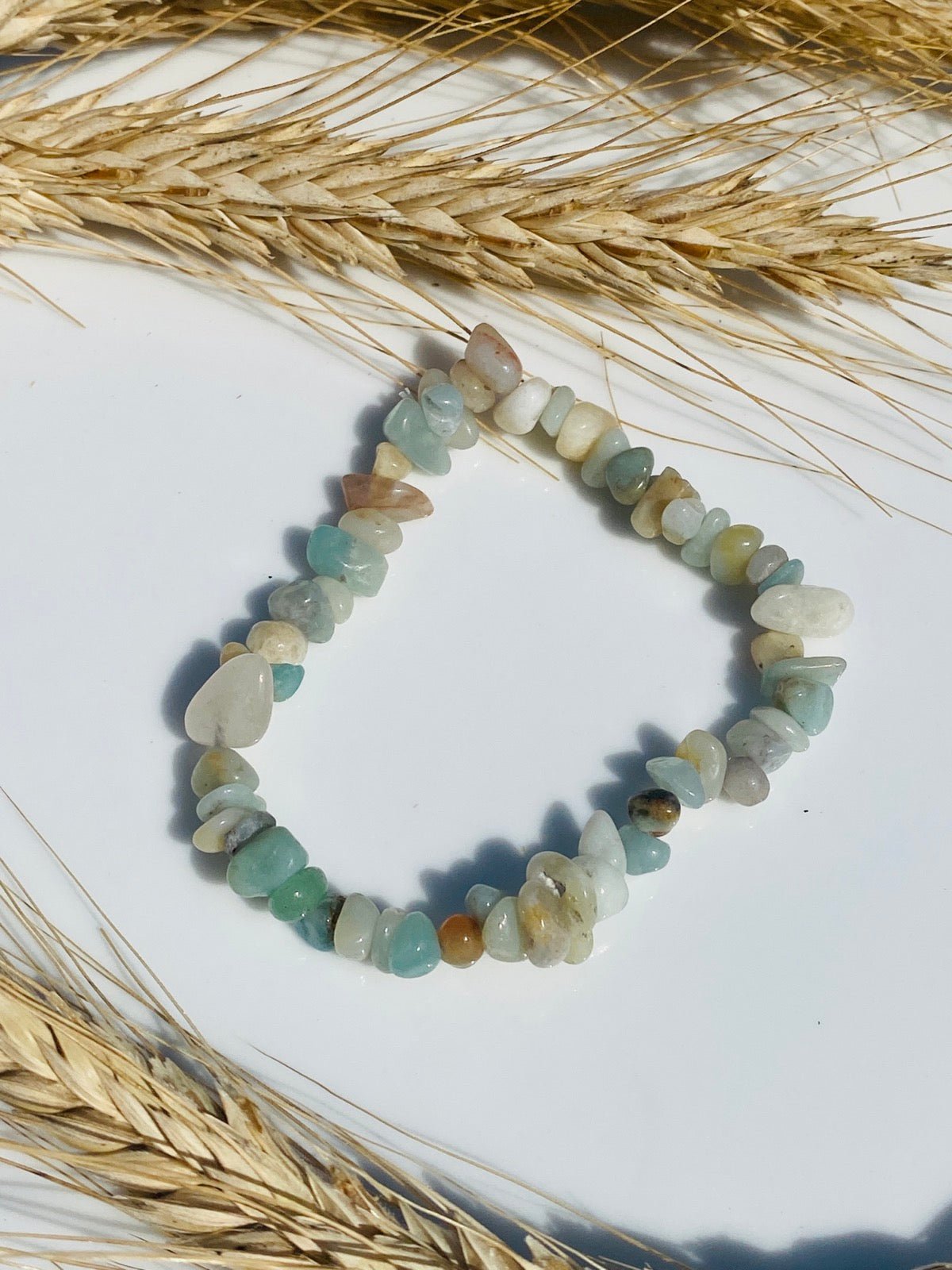 Splitterarmband auf weißem Hintergrund mit Weizen Deko