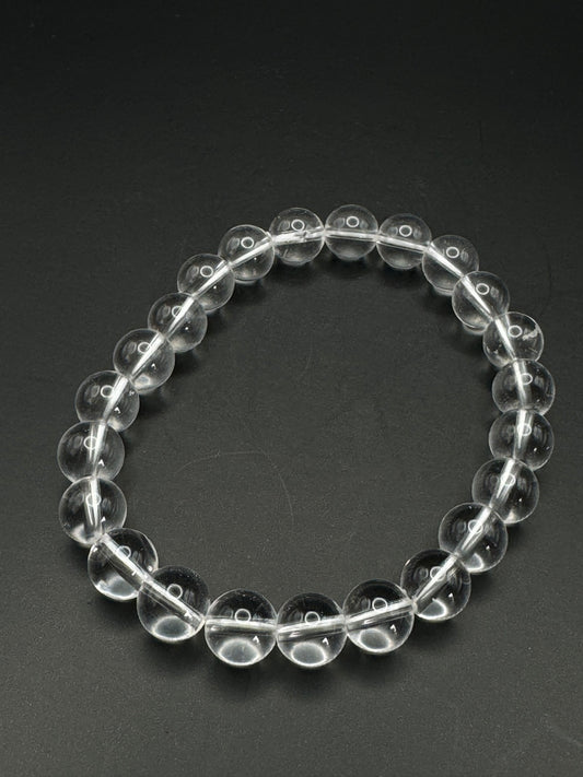 Bergkristall Armband mit 6 mm Perlen, transparent klar auf schwarzem Hintergrund.