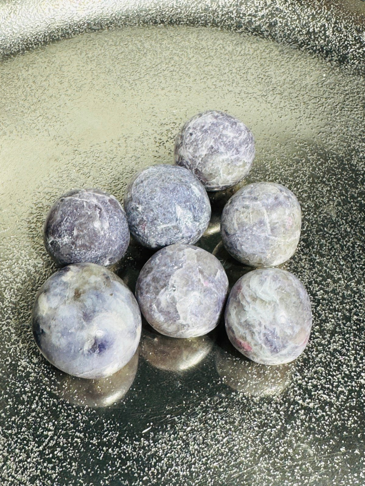 Unicorn Healing Stones made of Turmaline in lepidolith on silver table.